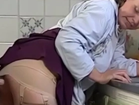 Mature woman indulges in sexual acts in the kitchen