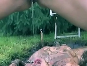 Mistress pissing on sub outdoors in the mud